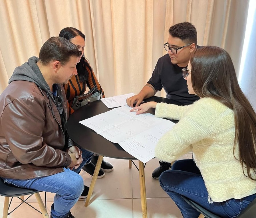 Família analisando financiamento e planta da casa
